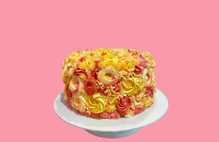 Decorative cake with yellow and orange rosettes for birthday celebrations