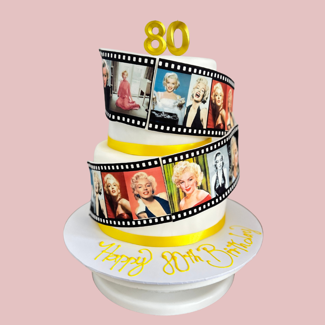 Two-tier birthday cake with film strip design and 'Happy 80th Birthday' Marilyn Monroe themed cake