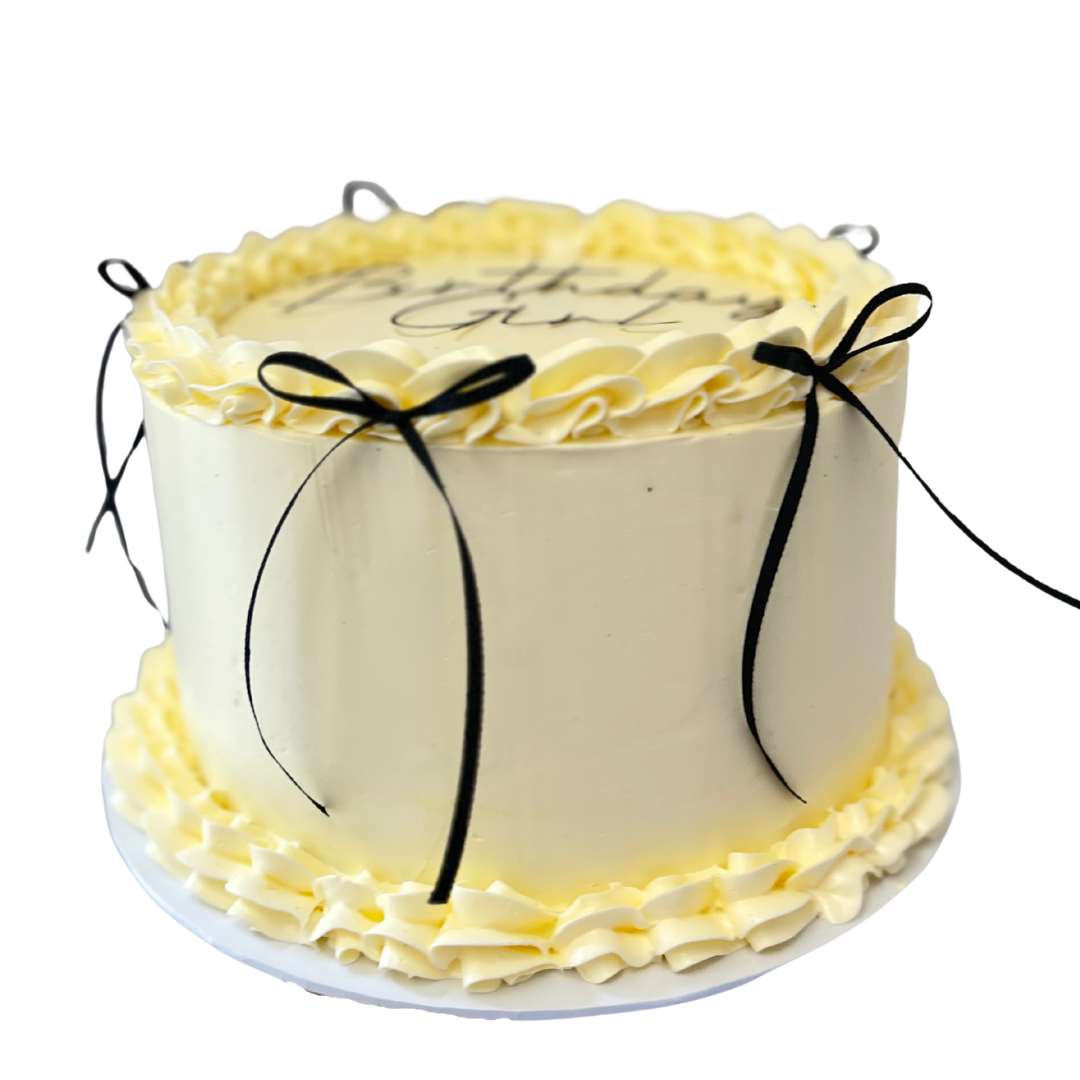 White cake with yellow frosting and black ribbons. Vintage style Lambeth cake in Kent 