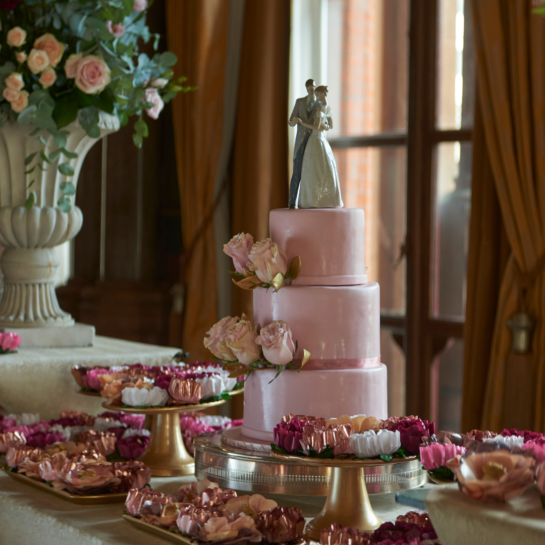 Bespoke wedding cake with pink icing and couple icing sugar on top. Make for renascence hotel in London.