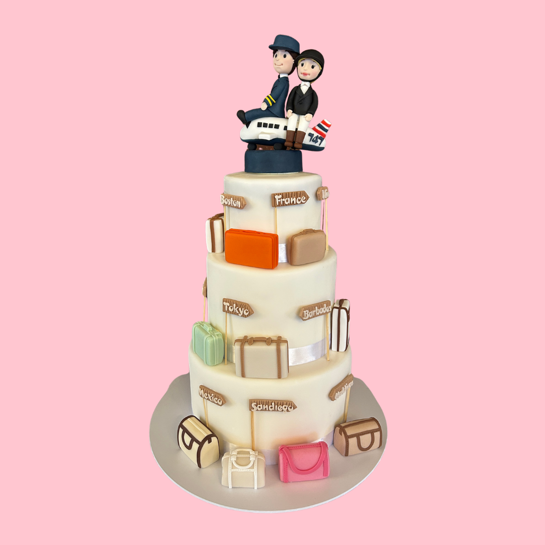 Three-tiered travel-themed cake with figurines on top. Made for a wedding in Central London