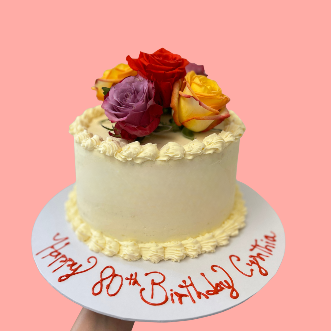 White birthday buttercream cake with colourful flowers for a 80th birthday 