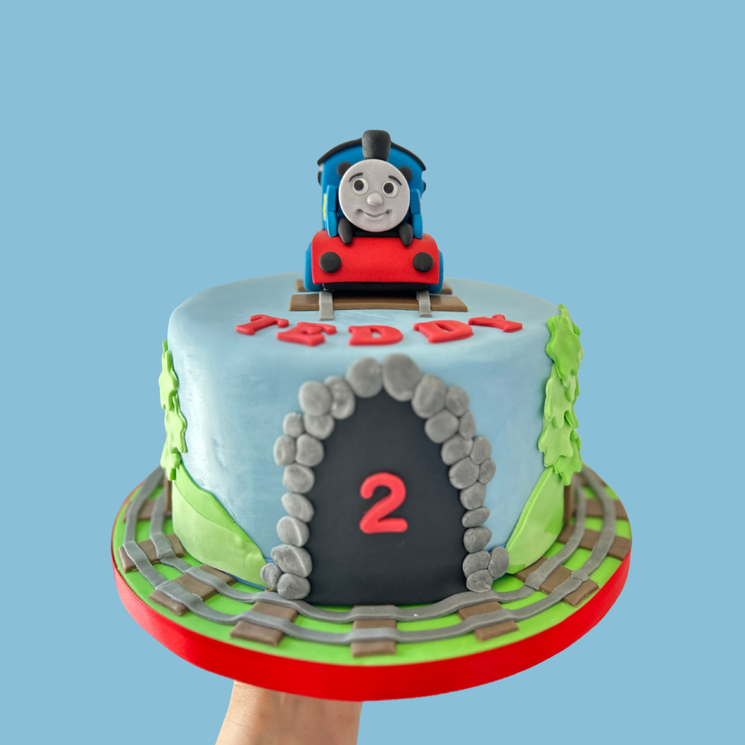 Cake with a train design and 'Happy 2nd Birthday' .Thomas the train themed cake